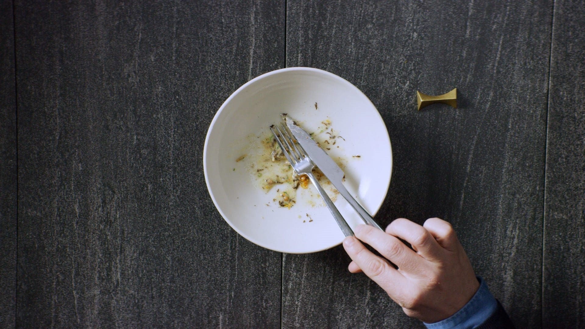 An empty plate with utensils resting on it, symbolizing the completion of a meal and the unseen forces of futures trading in the food industry.