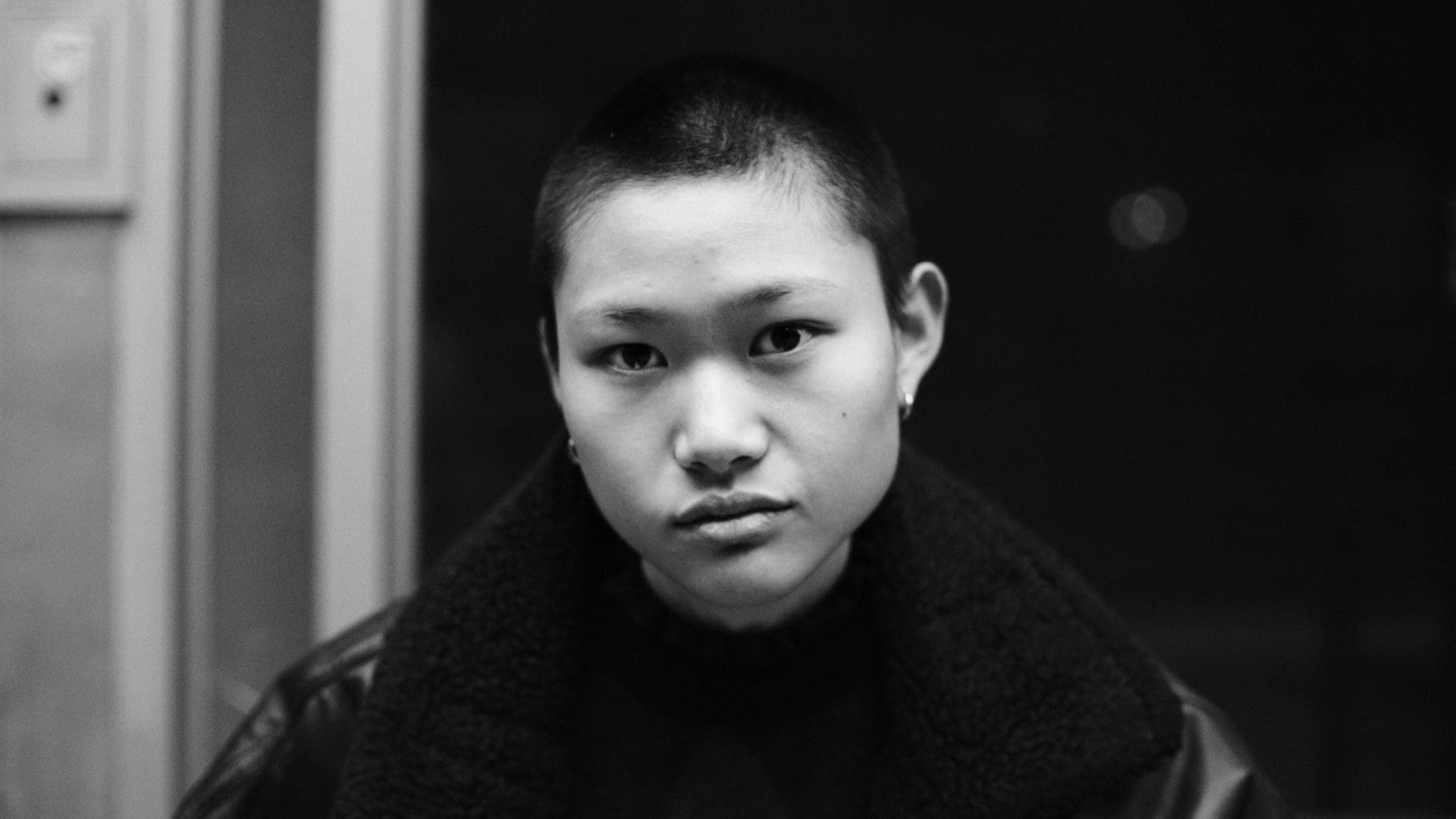 A powerful black-and-white portrait of a young individual captured during the filming of RIOT’s “The Future Is Unwritten,” showcasing resilience and hope.