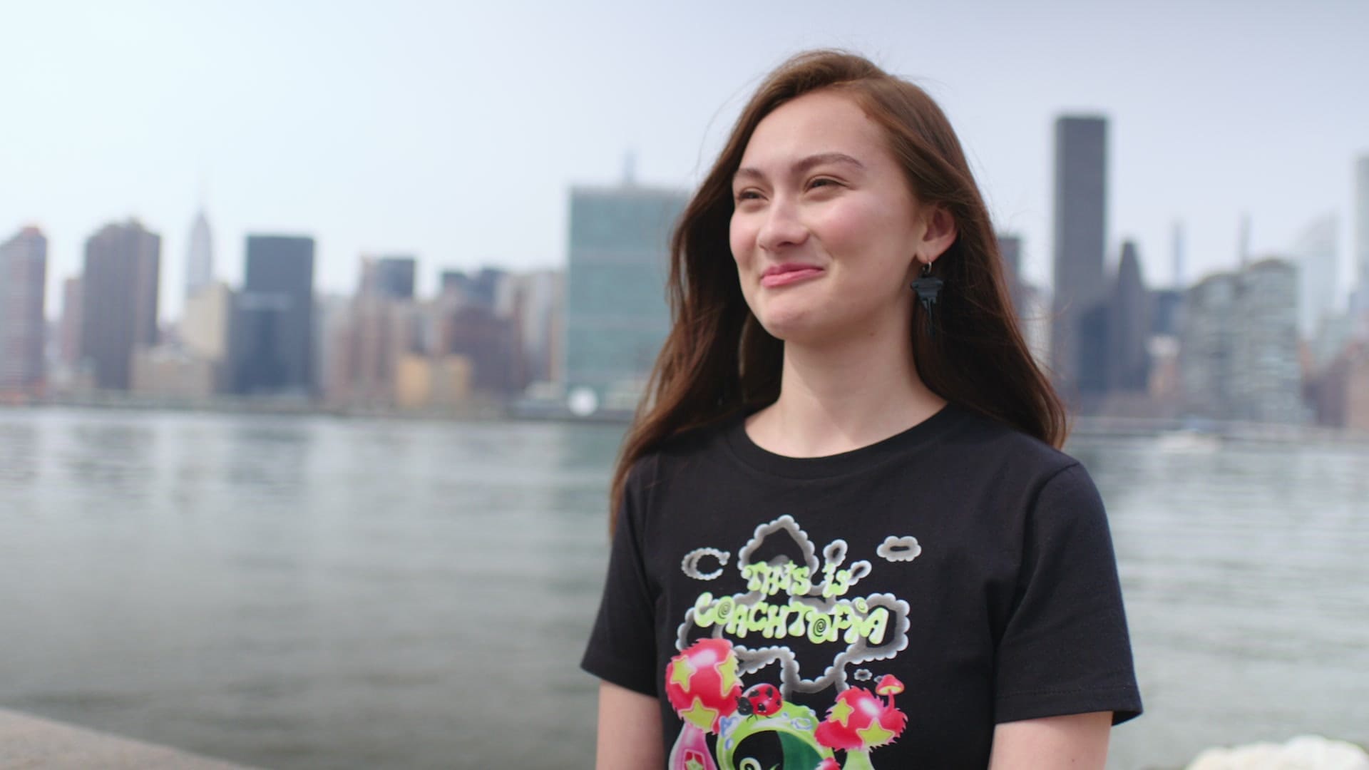 Lola Tung in a This Is Coachtopia T-shirt by the East River