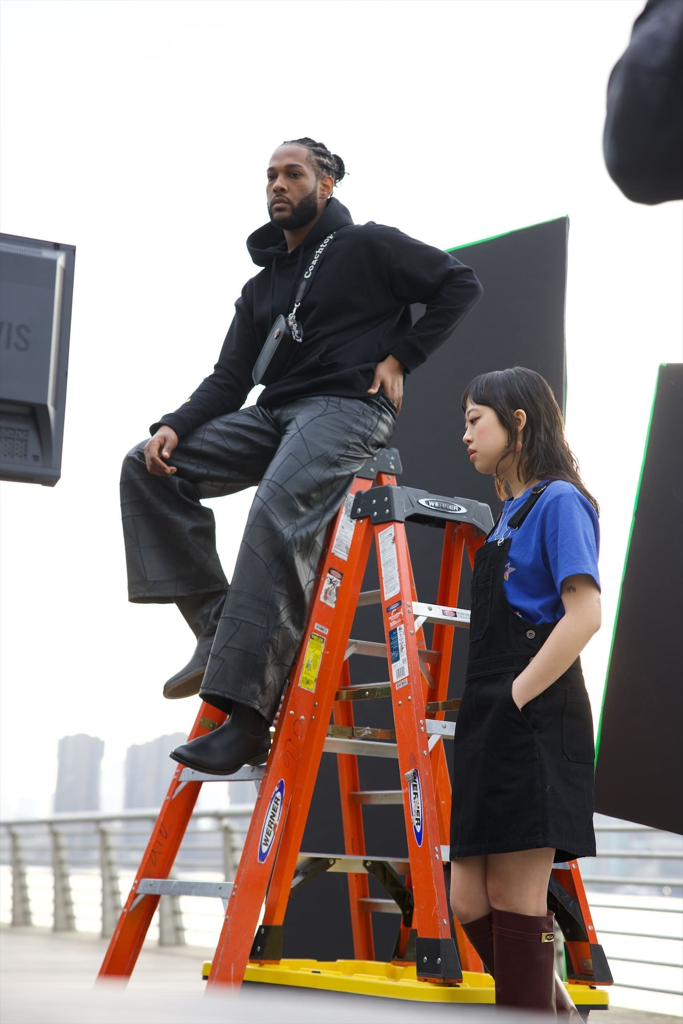Trey Denis sitting on an orange ladder with Sabrina Lau beside him