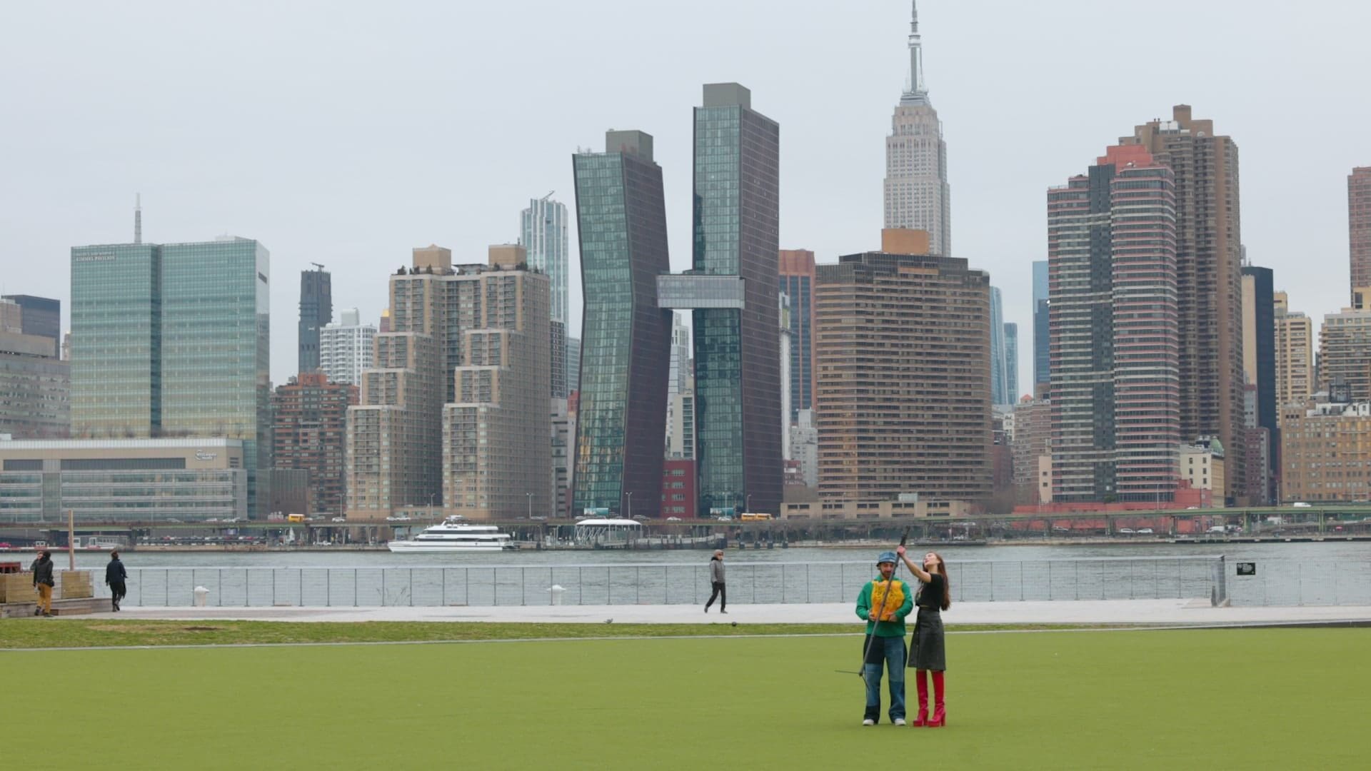 Two Coachtopians on the lawn at Gantry Plaza State Park with the Manhattan skyline across the river