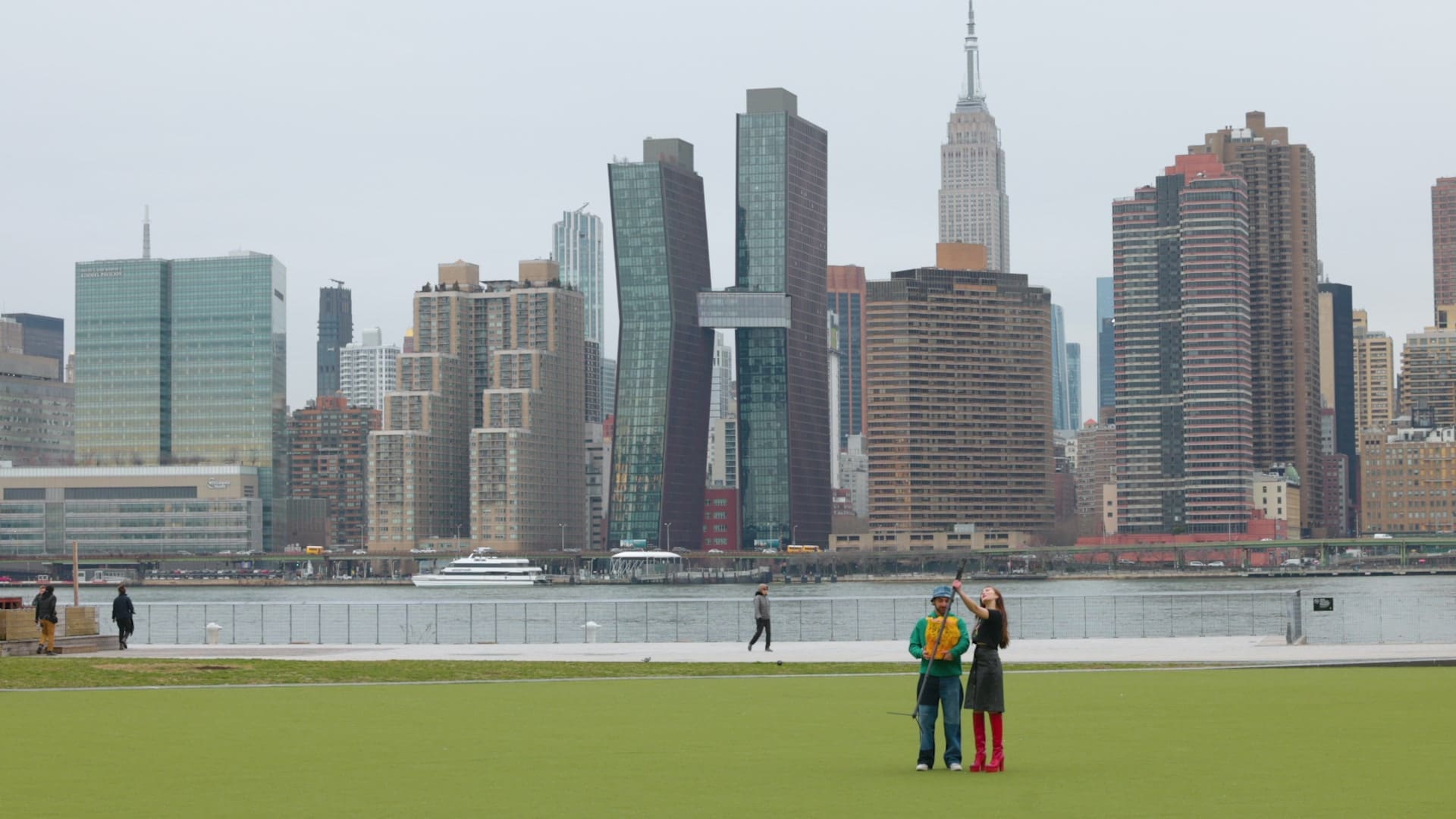 Two Coachtopians on the lawn at Gantry Plaza State Park with the Manhattan skyline across the river