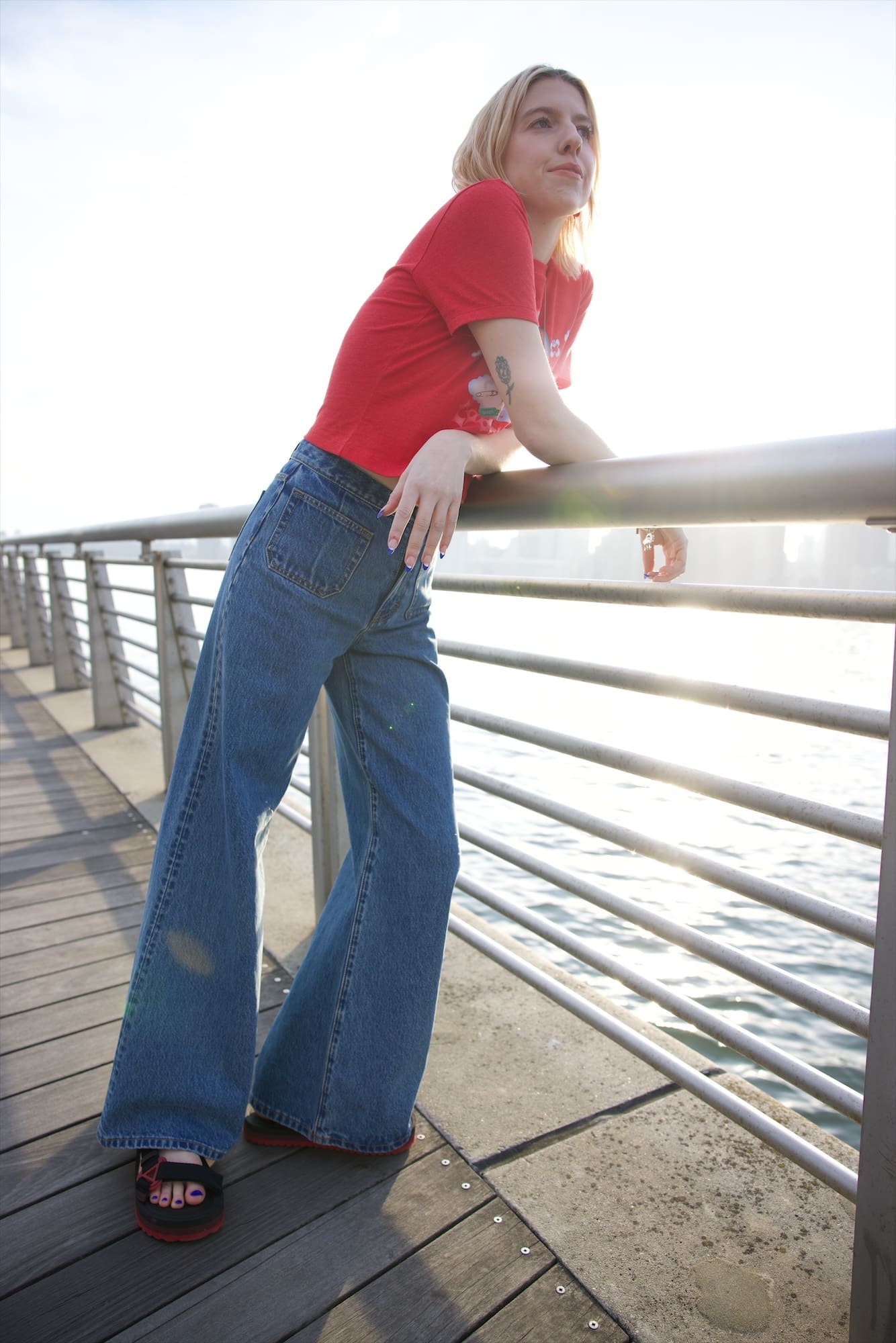 Tyler McGillivary in a red T-shirt leaning on the river rail