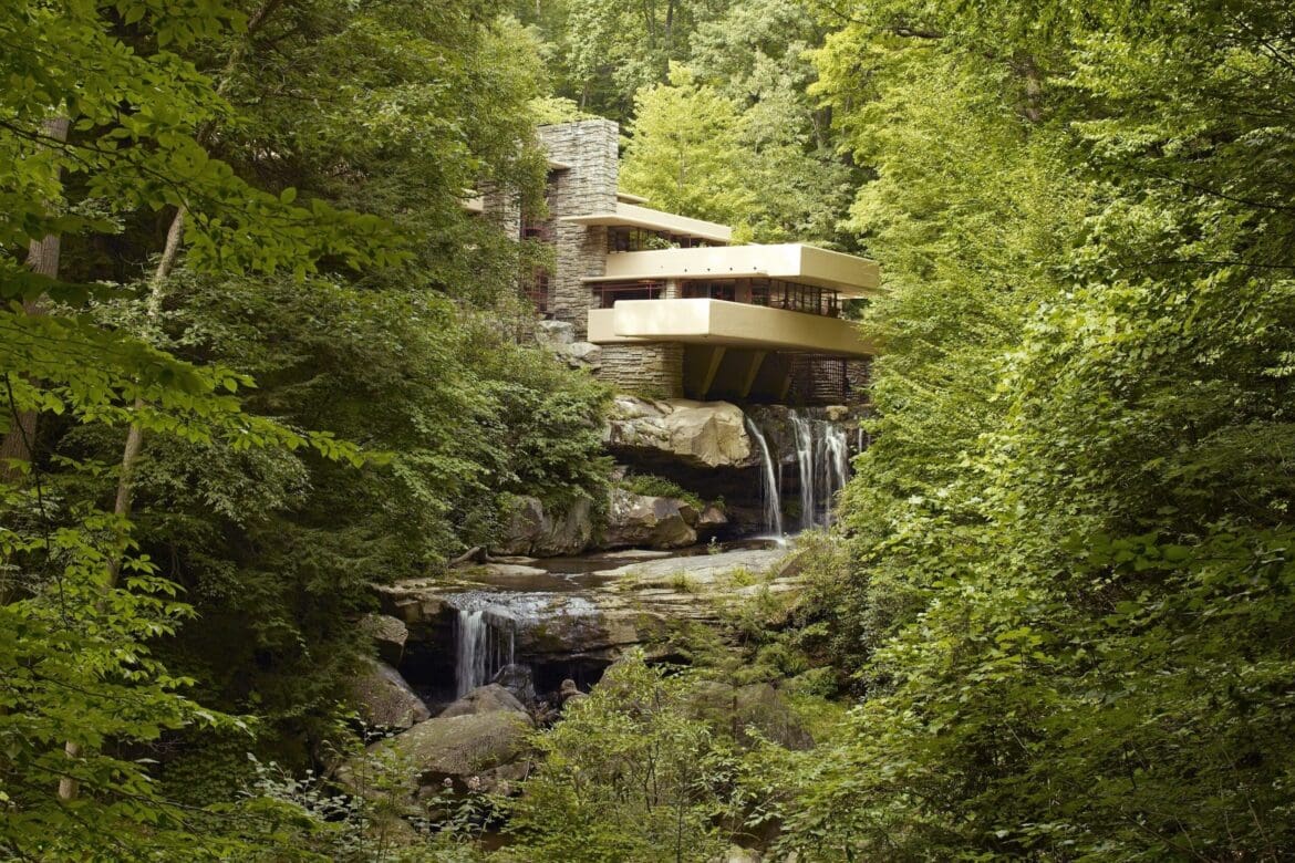 Fallingwater, a house designed by Frank Lloyd Wright, built over a waterfall and surrounded by lush green forest, as seen in 2007.