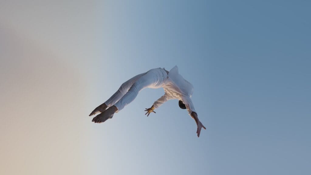 RIOT, NYC Creative Agency: A woman floats weightless against a pale sky, from the Bleed Electric Gravity music video A woman floats weightless against a pale sky, from the Bleed Electric Gravity music video