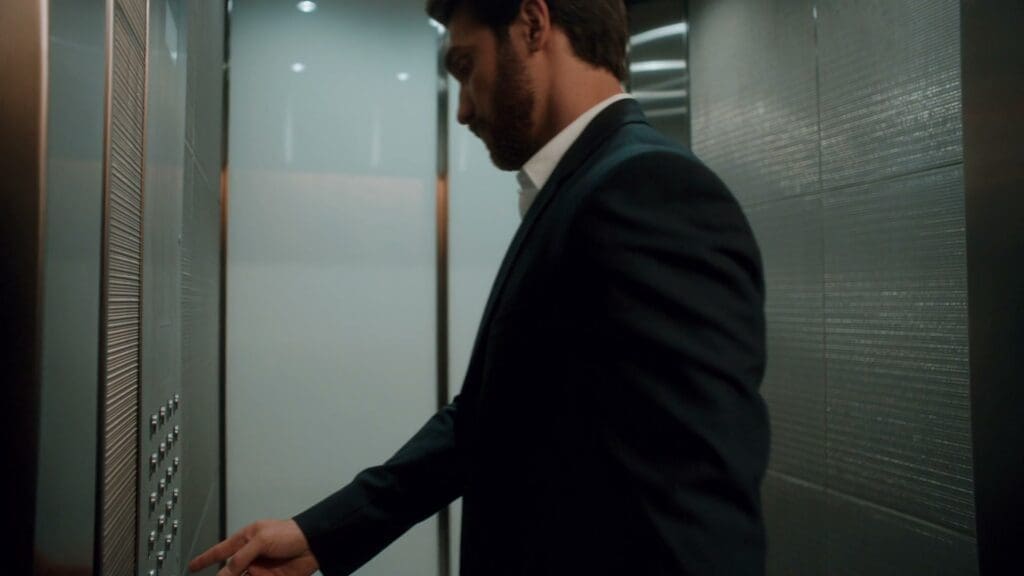 An executive in a suit stepping into an office elevator in Manhattan