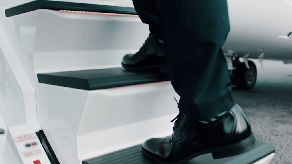 A polished shoe on the step of a NetJets jet