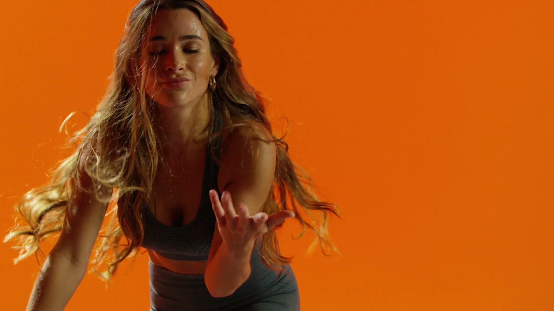 Samantha Jade leaning into the ride against an orange backdrop