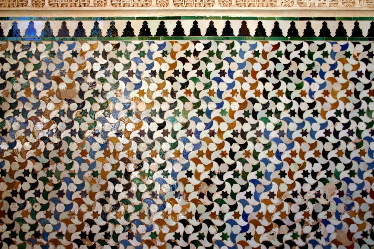 Colorful geometric tessellation patterns found in the Alhambra, showcasing Moorish art and design.