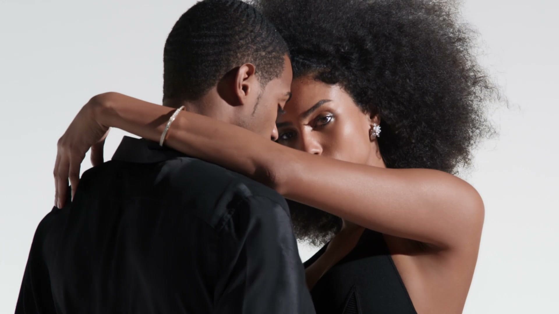 The Tiffany Lock campaign couple in an embrace, a diamond Lock bangle on her wrist